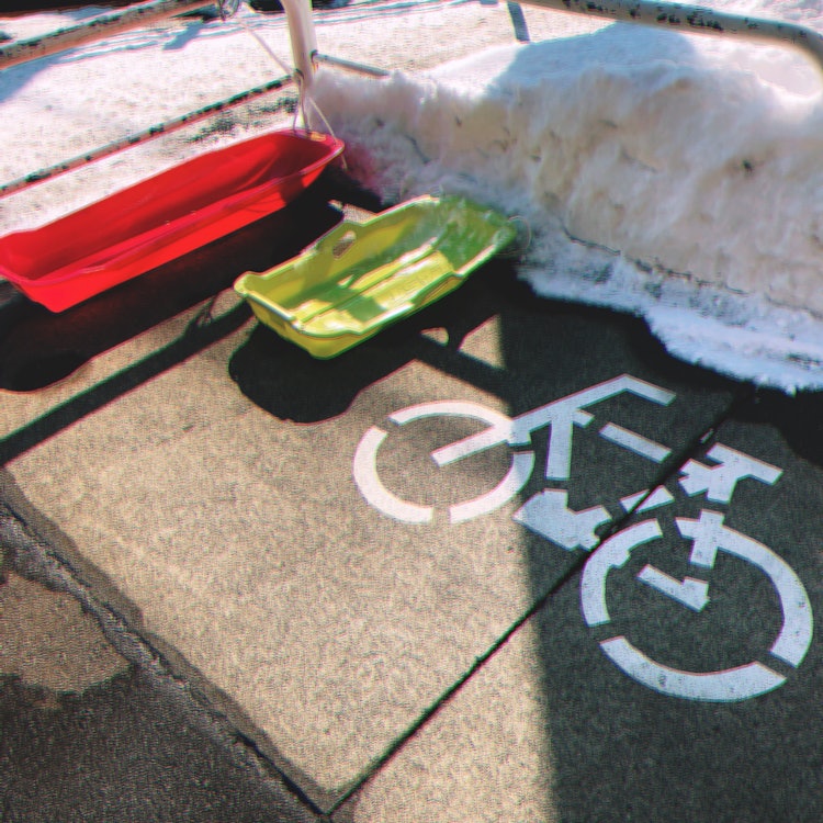 [이미지1]홋카이도 삿포로시의 모 쇼핑몰의 주륜장에서.홋카이도에서 썰매가 어린 아이들의 이동 수단이 되는 것은 드문 일이 아니지만, 자전거가 없는 한겨울, 자전거 주차장에 밝은 색의 썰매 2