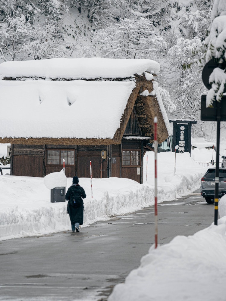 [Image1]This is a tourist walking through the snow-covered streets of Shirakawago Village.