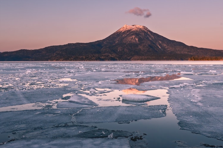 [画像1]雪解けの阿寒湖です湖面の氷が割れるのか４月この時期のわずか2、3日ですが夕陽に雄阿寒岳が染まりこんな絶景がみれます