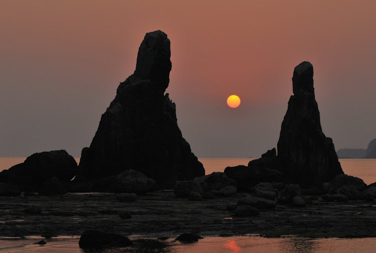 [相片1]這是和歌山縣串本町橋樁岩石的日出。 它是一塊因岩石的形狀而受到崇拜的岩石，也是一塊被稱為其門徒的岩石。 看起來是這樣，不是嗎？