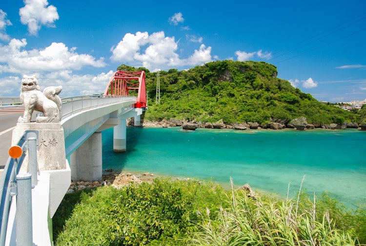 [画像1]伊計大橋 /沖縄本島中部の海中道路を通って宮城島と伊計島を結ぶ赤い橋です。エメラルドグリーンの海がとても綺麗です。 橋の上から見たほうが透明度があって凄くきれいですよ！ 沖縄の梅雨が終わる6月中旬から