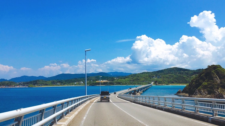 [画像1]山口県の角島大橋です。 綺麗な空と海、夏らしい雲、その中でのドライブは最高でした。 毎年行きたくなるスポットです。