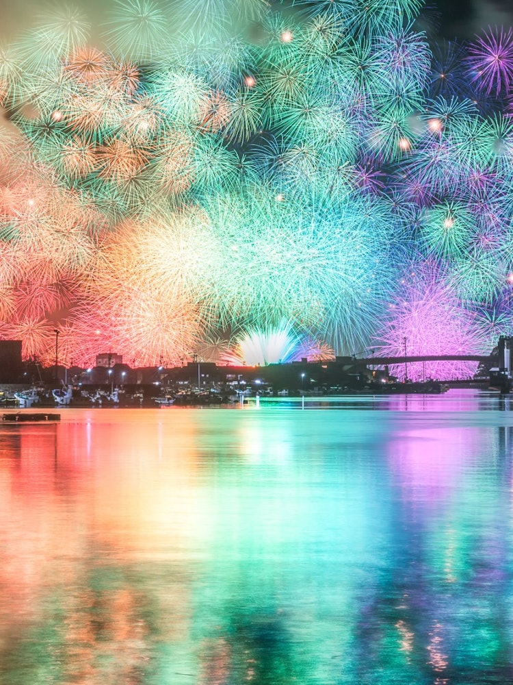 [이미지1]미에현에서 개최된 기호쿠 등불 축제의 사진입니다.주요 색깔의 공작은 부채꼴 모양으로 열리는 7 가지 색의 천 개의 고리를 가지고 있으며, 반대편 해안에서 촬영하면 수면에 반사되어 