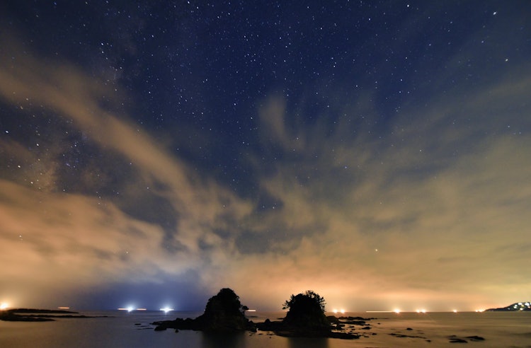 [相片1]在和歌山县白滨町的梅兹罗岛上，渔火倒映在流云中，我拍下了一张壮观的星空照片。