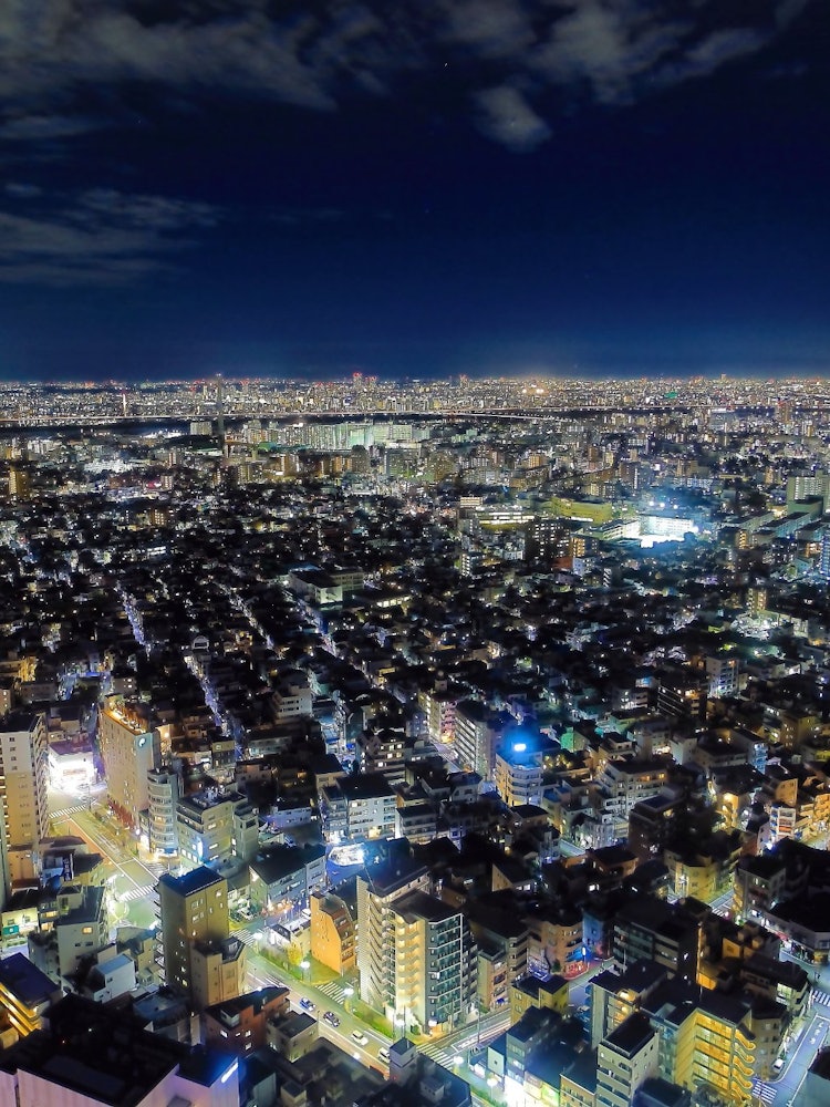 [画像1]スカイツリーイーストタワーから千葉方面の夜景を写しました。左下には東武伊勢崎線と京成押上線、右側には北十間川が通っていて、真ん中より少し上を荒川が横断しています。東京は世界一のメガシティで1955年ま
