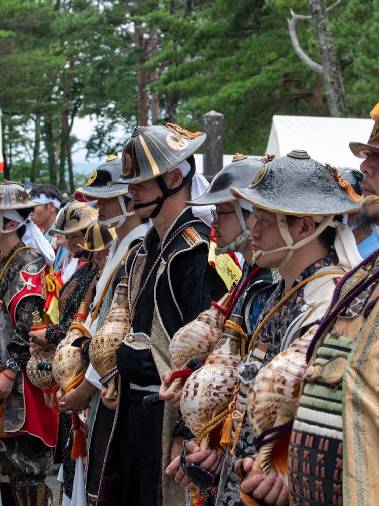 [画像1]福島県相馬地方で行われる相馬野馬追祭で御神輿を安置し、螺貝を吹く。