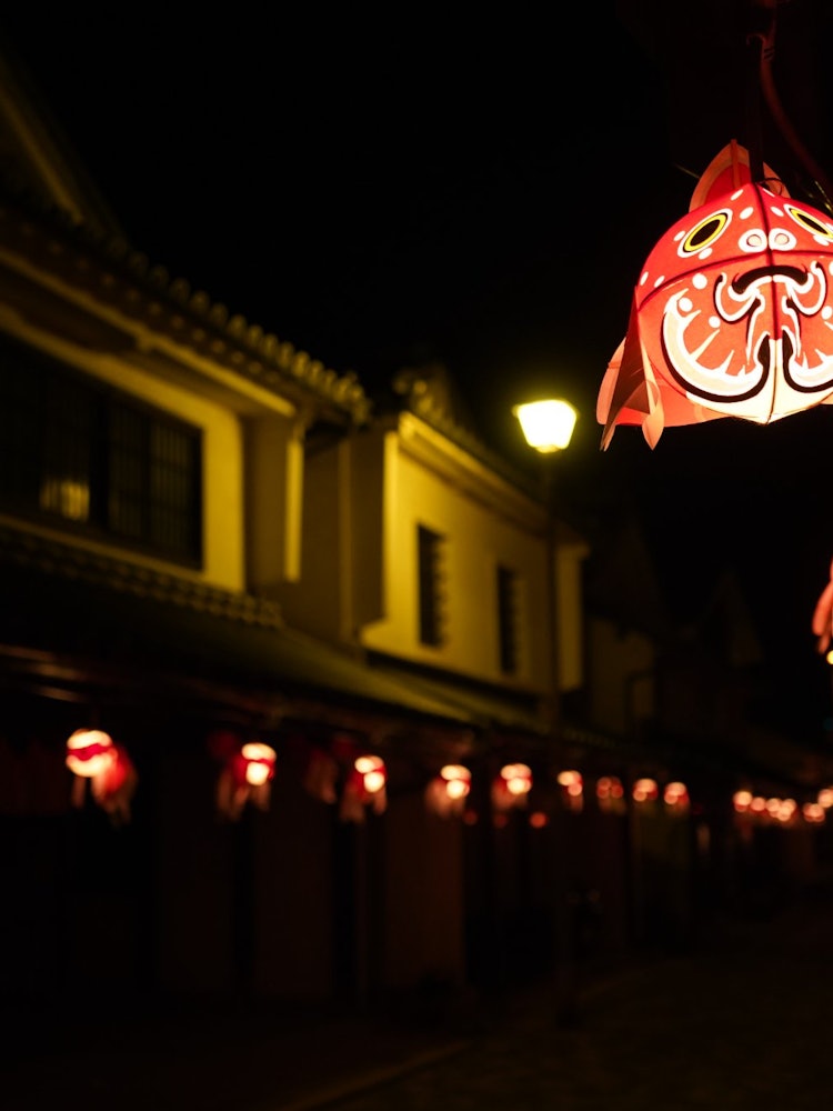 [画像1]山口県柳井市の祭り「柳井金魚ちょうちん祭り」です。白壁の街中で、ほのかに灯る「金魚のちょうちん」は、どこかユーモラスで、「金魚ちょうちん」から洩れる優しい灯りが幻想的な雰囲気を醸し出します。２０２３年