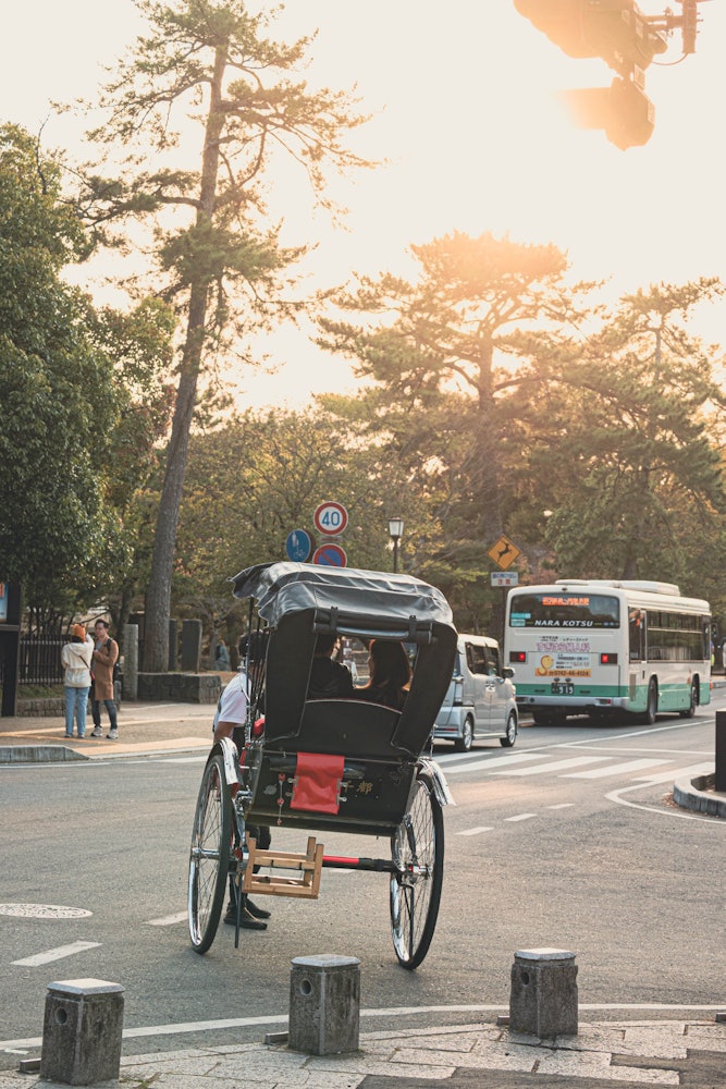 [画像1]奈良市の街で人力車に乗って観光する様子です。人力車で静かな街並みを眺めることができます。