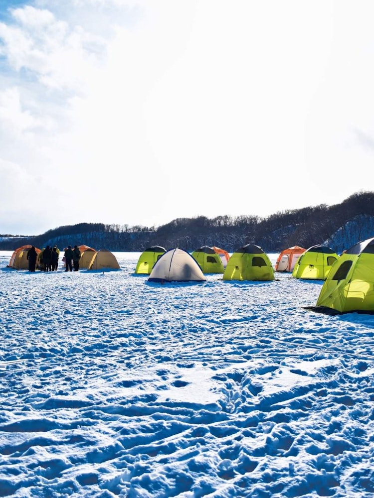 [画像1]冬の間、網走湖は完全に凍った湖になります。湖の真ん中を歩くこともできます。この時期のワカサギ釣りは北海道でとても人気があり、エキサイティングなイベントです。何人かの人がここに来てテントを作ります。テン