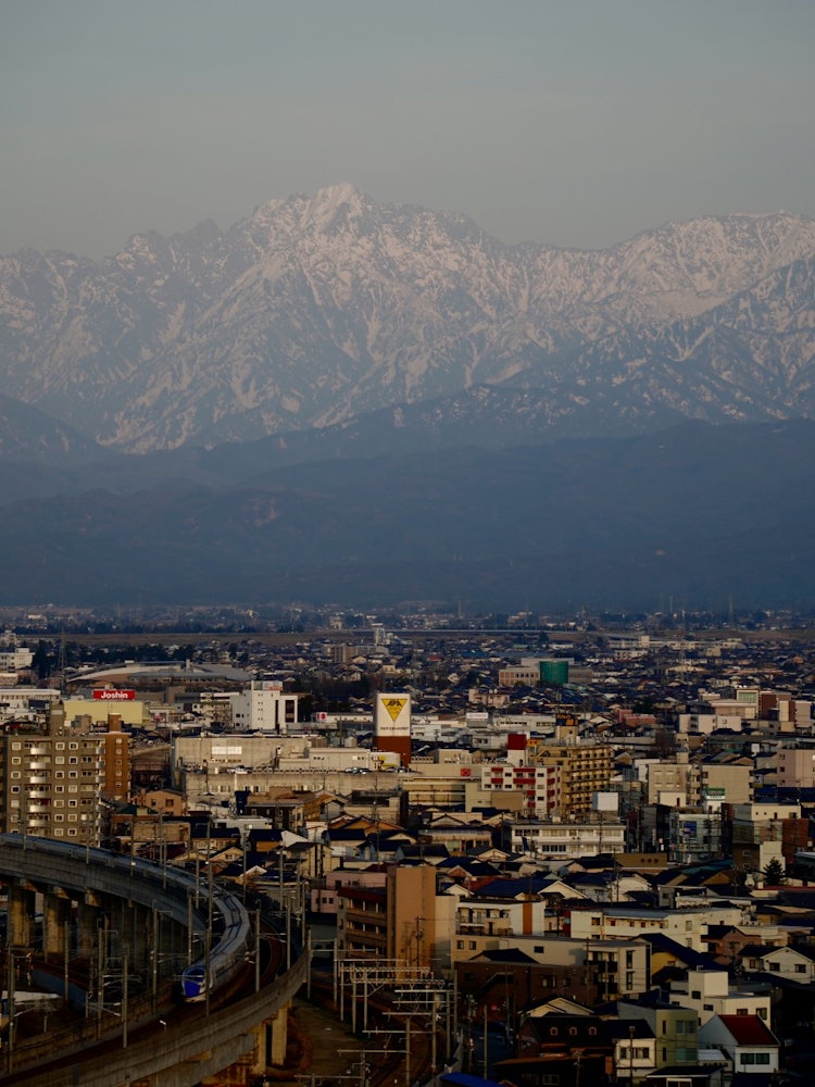 [相片1]这是春天的富山市，被阿尔卑斯山的群山所环绕。拥抱白雪皑皑，巍峨山气势磅礴。能登半岛地震的伤痕尚未愈合，但我们祈祷早日康复。