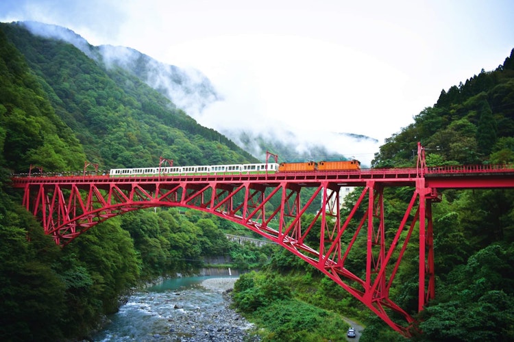 [이미지1]아름다운 붉은 다리, 푸른 산, 지나가는 구름과 깊은 스릴 넘치는 협곡은 다테야마 구로베 여행에서 목격한 것입니다. 지나가는 전철의 풍경 이 구로베 협곡에서 가장 긴 다리 너머로 