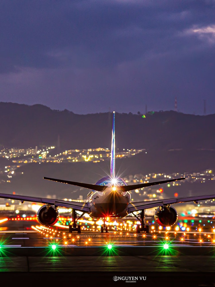 [Image1]Night view of Itami AirportAn airplane flies close to you from the Senri River.