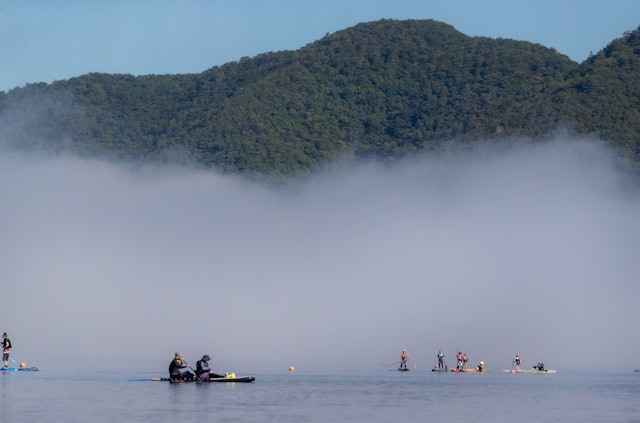 [Image1]夏休みの早朝。朝霧湧く本栖湖ではスタンドアップ・パドルボードで遊ぶ人達が大勢いました。
