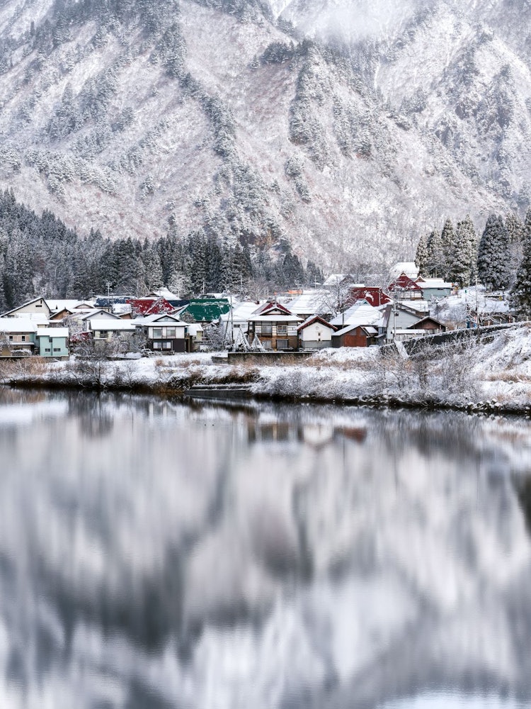 [Image1]A village reflected in the Tadami River. The world of white silver has been reversed, and a very unr
