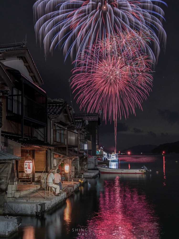 [画像1]京都府与謝郡伊根町。舟屋が立ち並ぶこの町で夏に行われる伊根花火。舟屋には御神灯が飾られノスタルジックな雰囲気に包まれます。