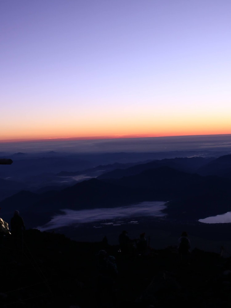 [画像1]富士山での御来光の直前。地平線をオレンジの蛍光ペンでなぞったような一枚。