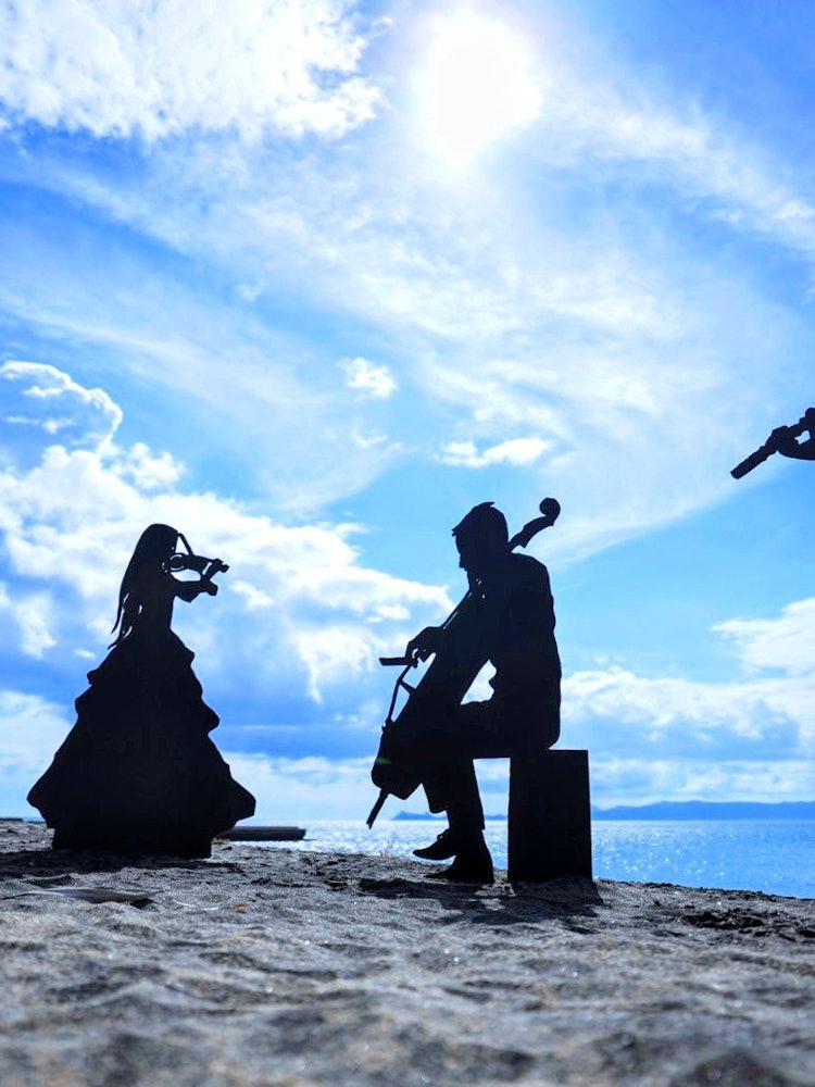 [画像1]【砂浜の音楽会】鹿児島県にある神川ビーチに行ってきました。 対岸の薩摩半島に沈む夕日と影絵が有名な場所ですが、この日はあえて夏の青空の下足を運びました!真っ青な青空と、キラキラした水面、そして影絵の黒